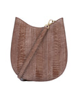 Front of a brown handbag with ostrich leg textured with a strap on a white background