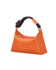 Orange handbag with a braided knotted handle on a white background