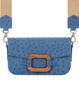 Front of a blue ostrich textured handbag with straps on a white background