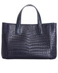 Back of a navy crocodile textured handbag on a white background
