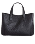 Back of a black ostrich textured handbag on a white background
