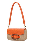 Side of a orange and beige ostrich and woven handbag with a strap on a white background