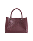 Maroon handbag with a textured pattern on a white background