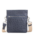Navy ostrich leather crossbody bag with zipper and strap on a white background