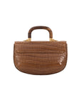 Back of brown crocodile handbag with a wooden handle on a white background