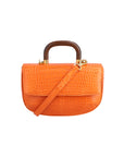 Front of a tangerine crocodile textured handbag with a strap and wooden handle on a white background