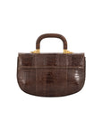 Back of a brown textured handbag with gold accents and a wooden handle on a white background
