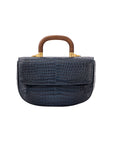 Front of a navy crocodile handbag with a wooden handle on a white background