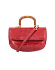 Red crocodile handbag with a wooden handle on a white background