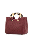 Side of jungle red ostrich handbag with a handle on a white background
