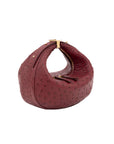 Maroon ostrich-textured handbag with gold zipper on a white background