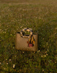 Jungle green ostrich-textured handbag on grass