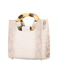 Side of a white textured handbag on a white background