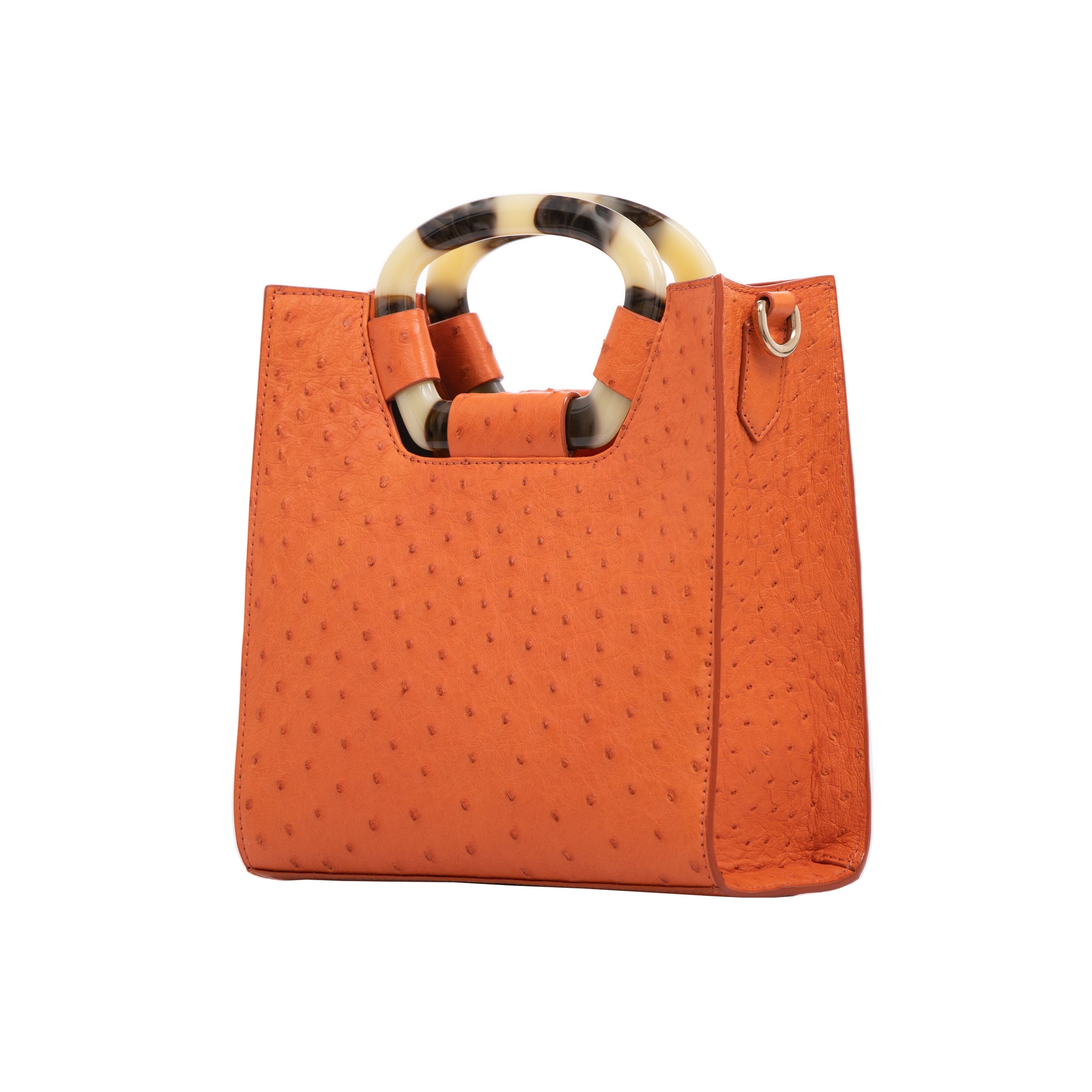 Side of a tangerine ostrich textured handbag on a white background