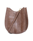 Side of a brown handbag with ostrich leg textured with a strap on a white background
