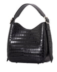 Side of a black crocodile textured handbag on a white background