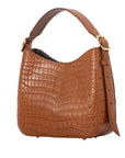 Side of a brown crocodile textured handbag on a white background