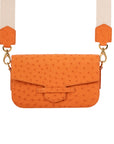 Orange ostrich textured handbag with a beige strap on a white background