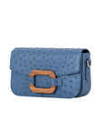 Side of a blue ostrich textured handbag on a white background