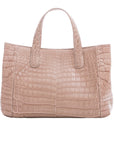 Back of a walnut crocodile textured handbag on a white background