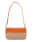 Back of a tangerine and beige ostrich and woven handbag with a strap on a white background