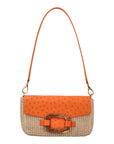 Front of a tangerine and beige ostrich and woven handbag with a strap on a white background