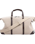 Large beige bag with brown crocodile straps on a white background