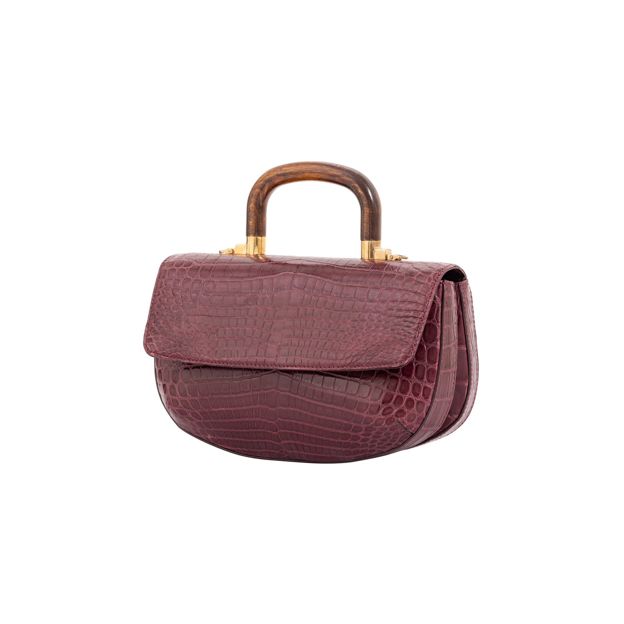 Side of a maroon crocodile handbag with a wooden handle on a white background