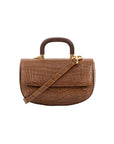 Front of brown crocodile handbag with a wooden handle and a strap on a white background