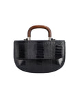 Side of a black textured handbag with wooden handle on a white background