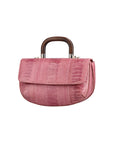 Side of a pink textured handbag with wooden handle on a white background