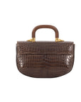 Back of a brown textured handbag with a wooden handle on a white background