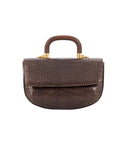Front of a brown crocodile handbag with a wooden handle on a white background