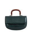 Back of a green crocodile handbag with a wooden handle on a white background