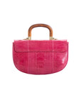 Back of a pink handbag with wooden handle on a white background