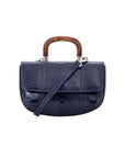 Front of a navy ostrich leg handbag with a strap and a wooden handle on a white background