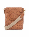 Cognac ostrich messenger bag with a strap on a white background