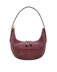Maroon crocodile-patterned handbag with gold accents on a white background