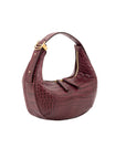 Maroon crocodile-patterned handbag with gold accents on a white background