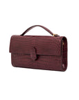 Side of crocodile red textured clutch bag on a white background