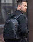 Men wearing a black python textured backpack 