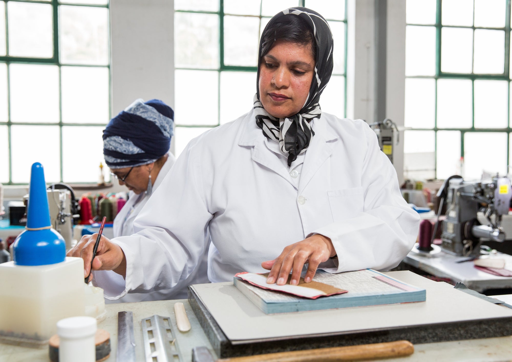 Two people working in a material factory busy with leather materail