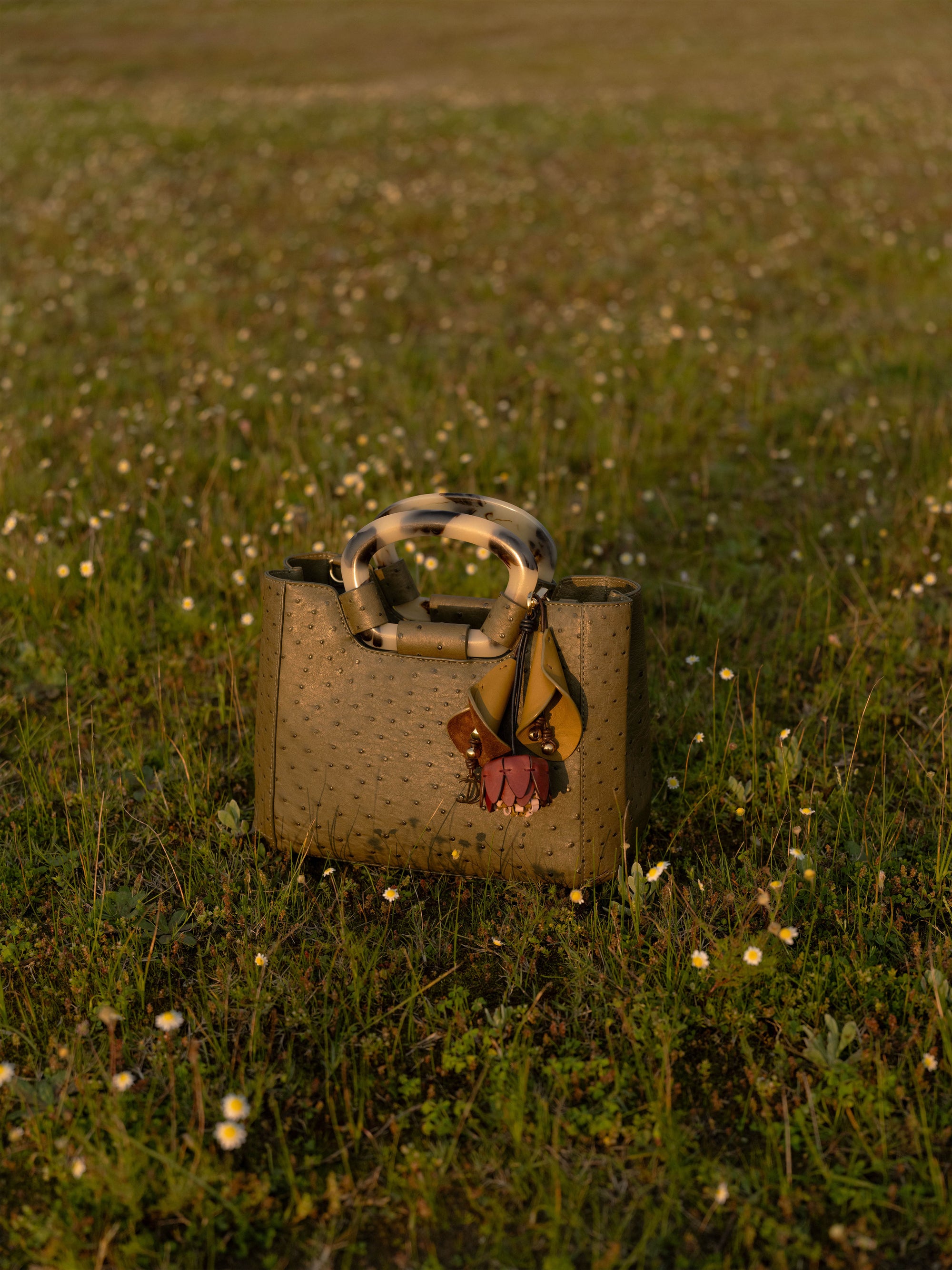 Jungle green ostrich-textured handbag on grass