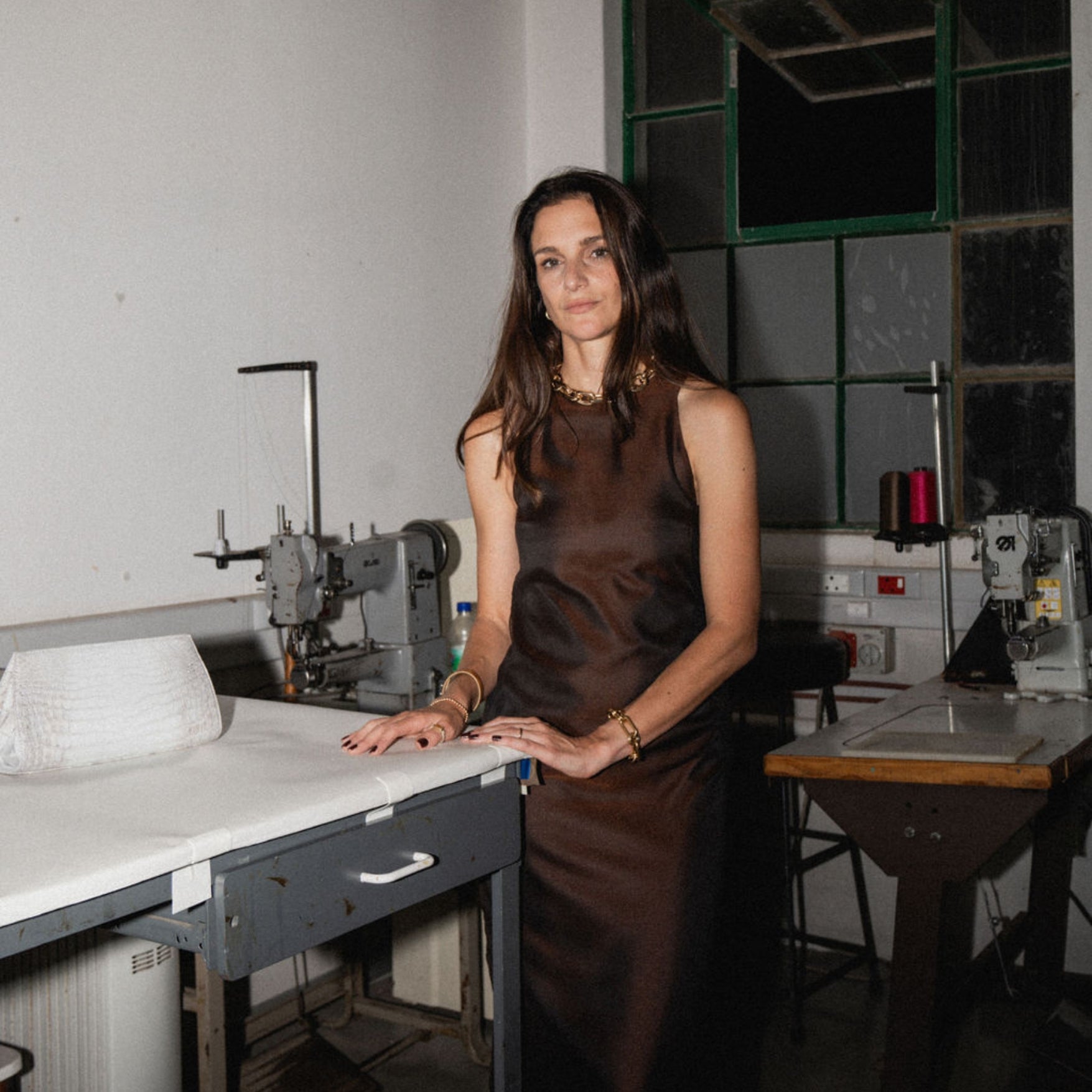 Woman standing next to various sewing stations