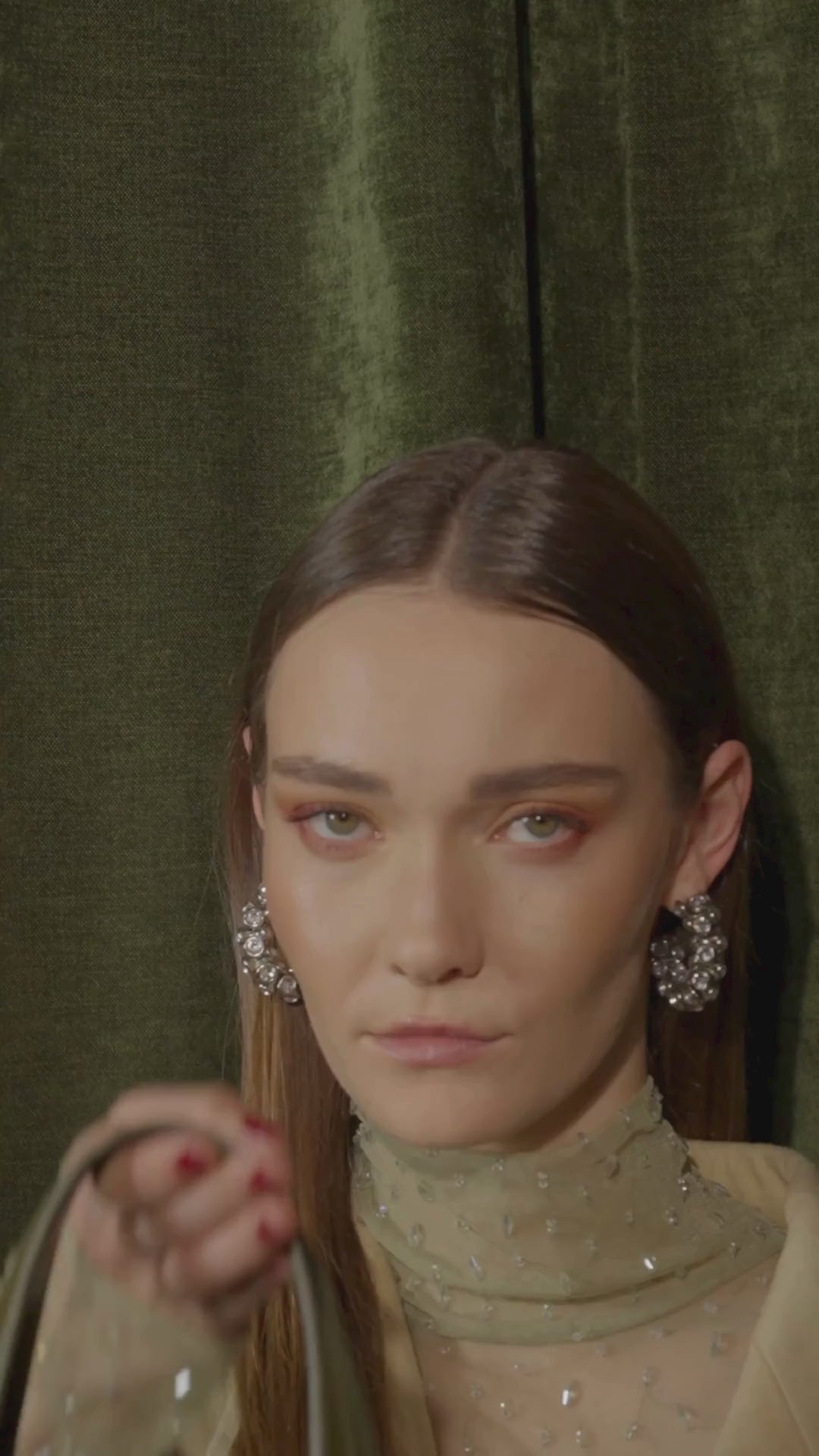 Woman modeling with a green suede handbag